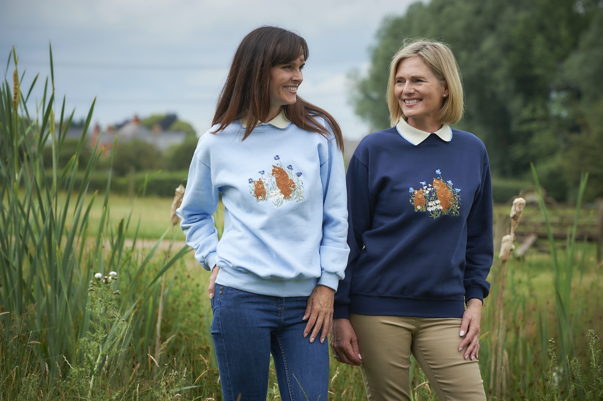 Two ladies where different shades of blue collared sweatshirts with floral pattern