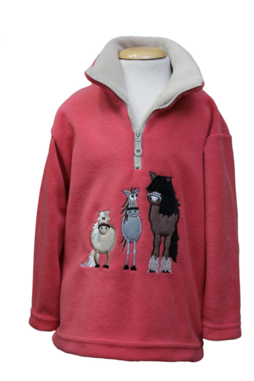 A child's coral coloured 1/4 zip fleece, featuring a cream coloured lining, and three cute, cartoon-style horses on the front.