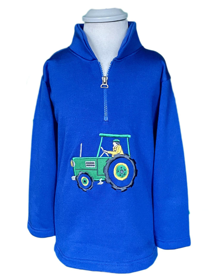 A child's blue 1/4 zip fleece with a green tractor on it.